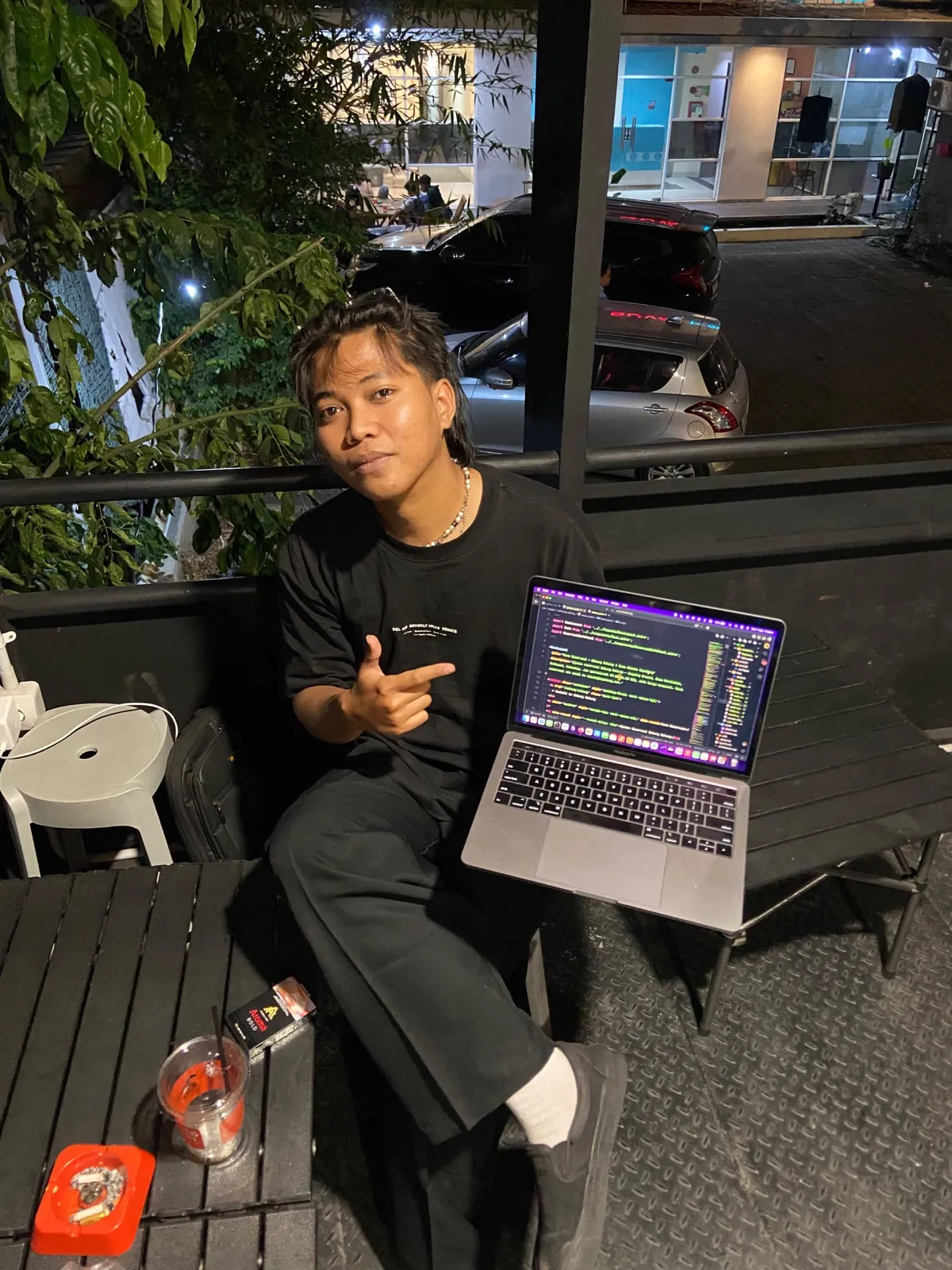 A night coding session on a café balcony, laptop open
